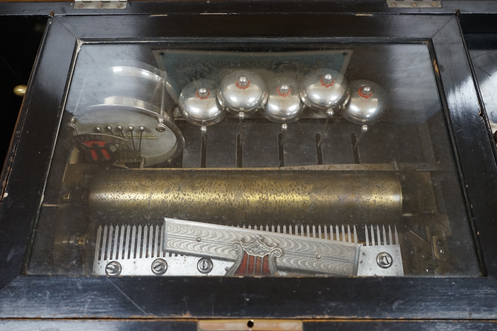 A late 19th century Swiss music box in a rosewood and ebonised case, playing twelve airs on a 52 tooth comb, five bells and a drum, 60cm wide, 27cm high, 32.5cm deep.